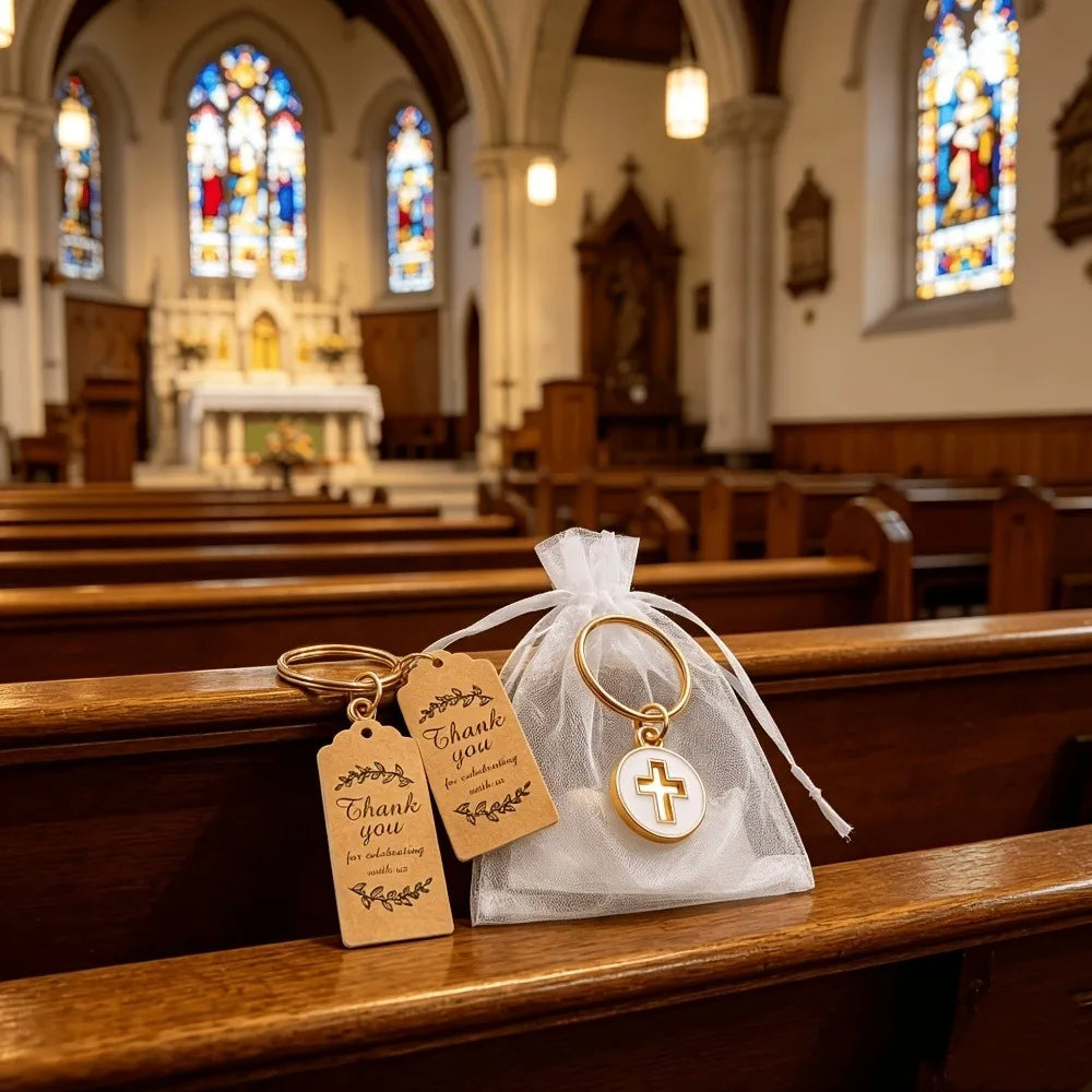 A gold cross keychain with a thank you card is displayed on a wooden church pew.