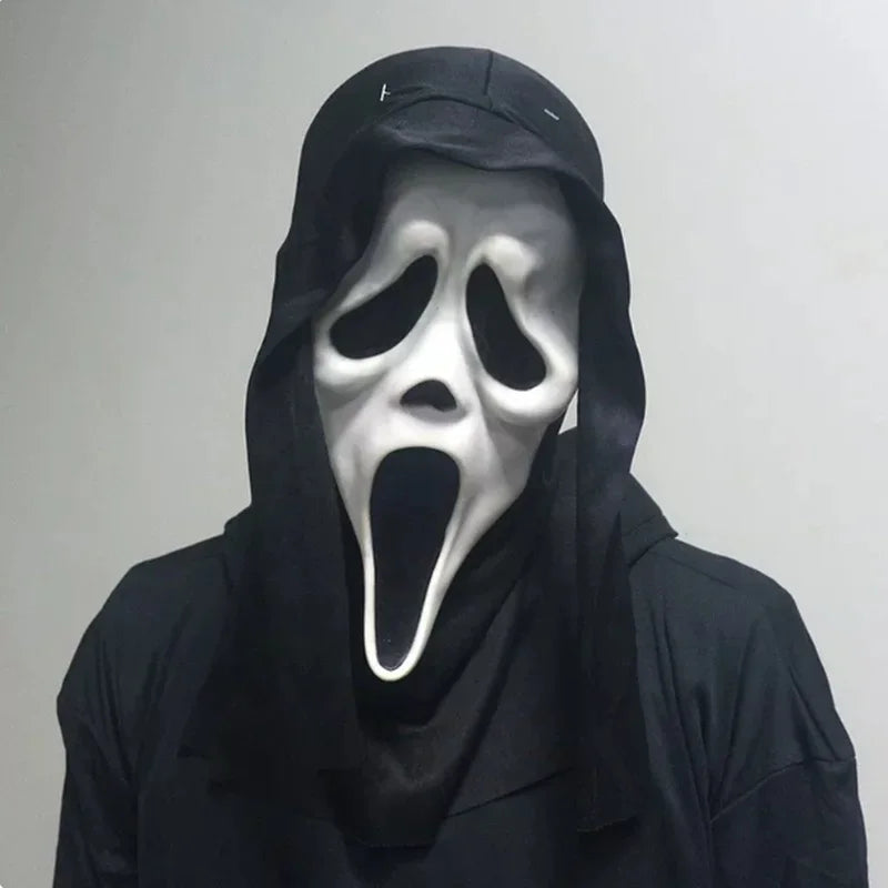 A person wearing a realistic Scream Ghost Face mask with a gaping mouth and hood against a light gray background.