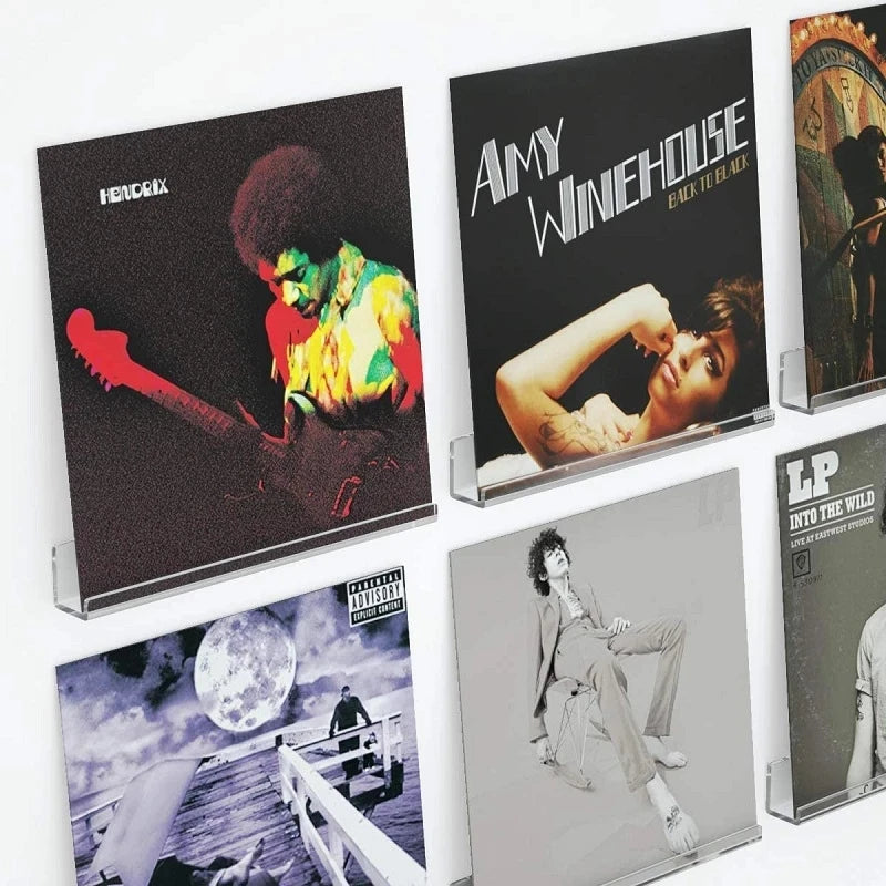 A display shelf featuring several acrylic vinyl record displays with album covers.