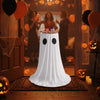 A white ghost-shaped dress with black eyes stands on a rug in a dimly lit room decorated for Halloween.