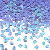 A pile of iridescent blue and purple sea shell PVC sequins for nail art and craft decoration.