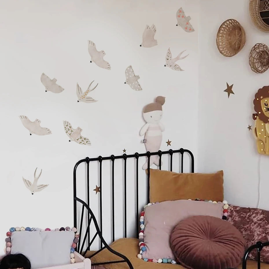 Schlafzimmerwand mit wiederverwendbaren Cartoon-Vogel-Aufklebern und einem schwarzen Metallbettrahmen.