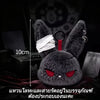 A dark gray bunny plush keychain with red eyes and white accents resting on a red fabric.