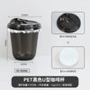 A black disposable U-shaped PET coffee cup with a lid and a white plastic sleeve.