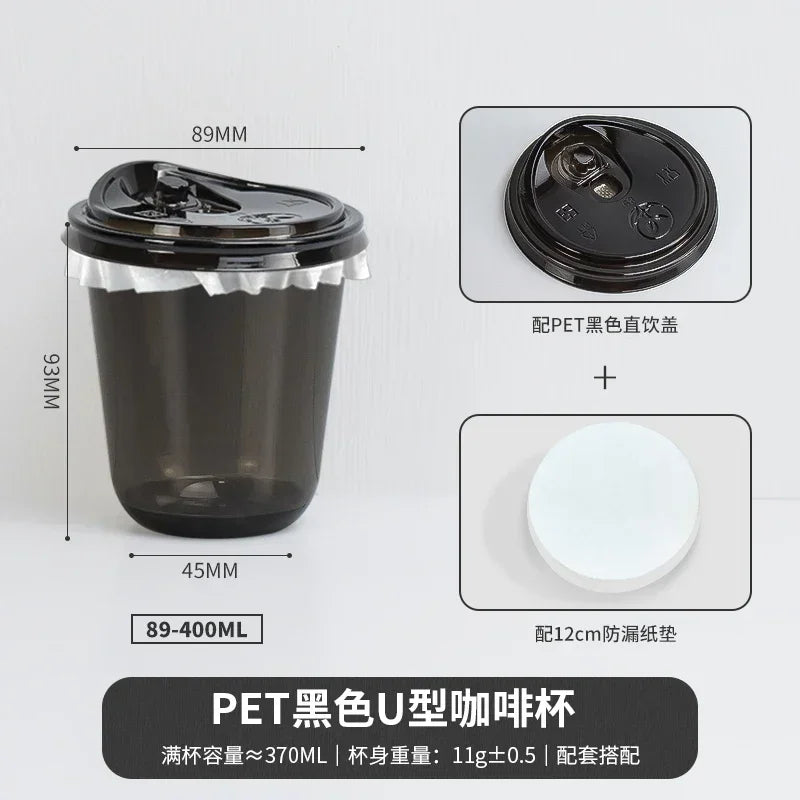 A black disposable U-shaped PET coffee cup with a lid and a white plastic sleeve.