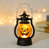 A black hanging lantern with an orange glow shaped like a carved jack-o'-lantern face.