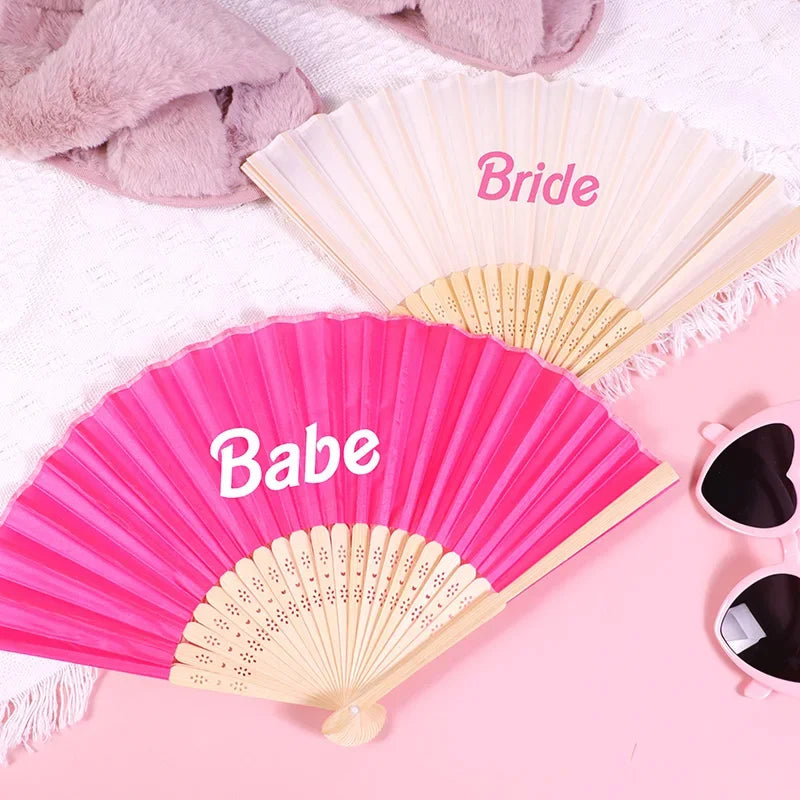 Pink hand fans labeled Bride and Babe displayed on a pink background
