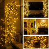 A vertical display of warm yellow LED willow vine lights decorating a wall and a dark wooden cabinet.