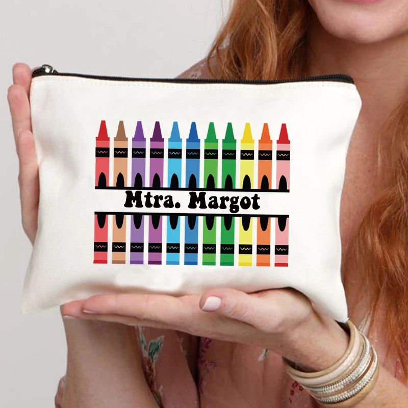 A cream-colored makeup bag featuring a colorful row of pencil-shaped embellishments.