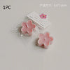 A single pink flower-shaped soy wax tea light candle is shown in clear packaging.