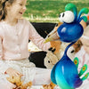 A young girl smiles while interacting with a blue metal peacock garden sculpture outdoors.