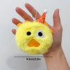 A yellow plush doll with an orange cone hat is held in a person's hand.