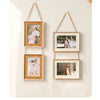 A set of three rustic wooden collage photo frames with natural twine hanging on a light wall.