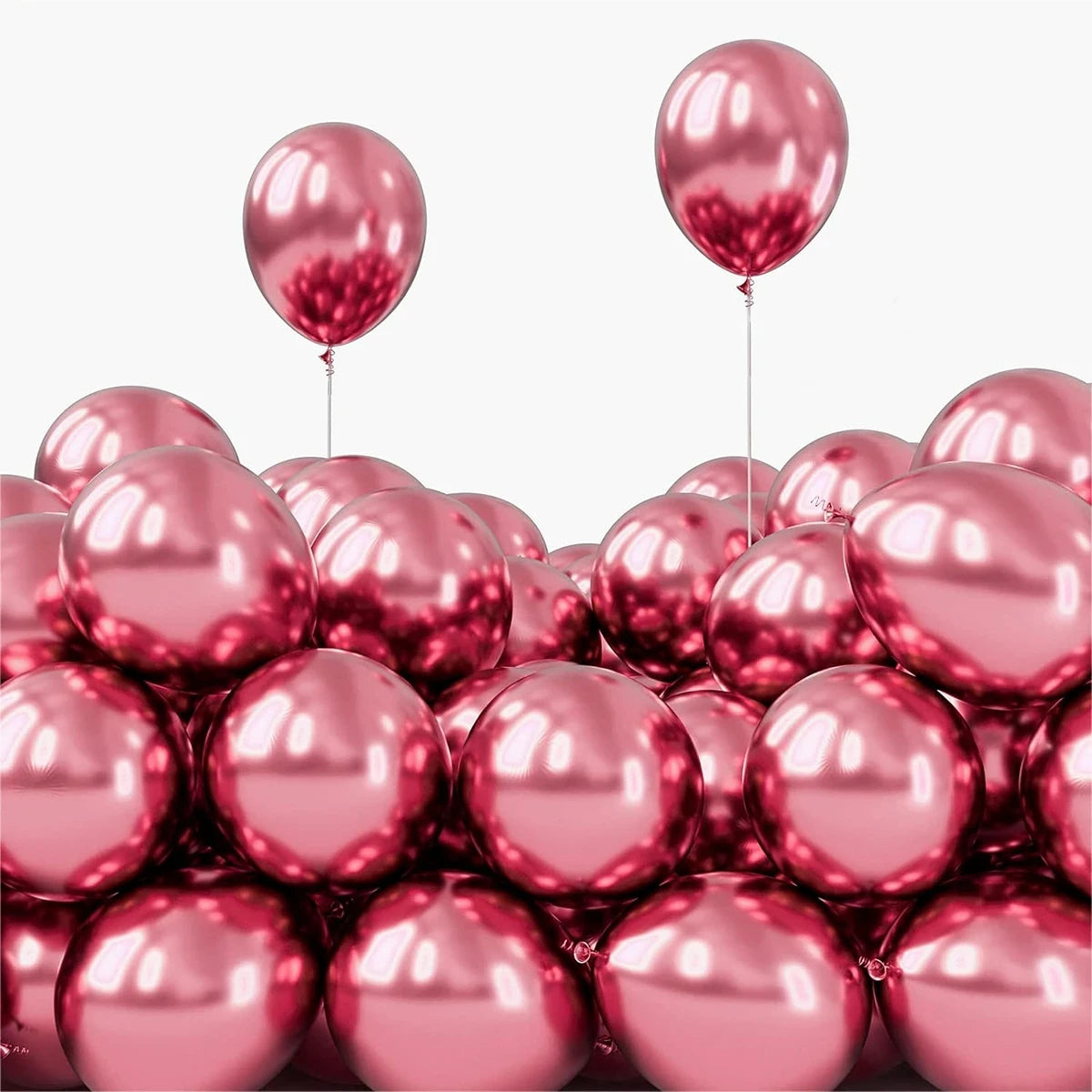 A pile of shiny pink chrome metallic balloons against a white background.