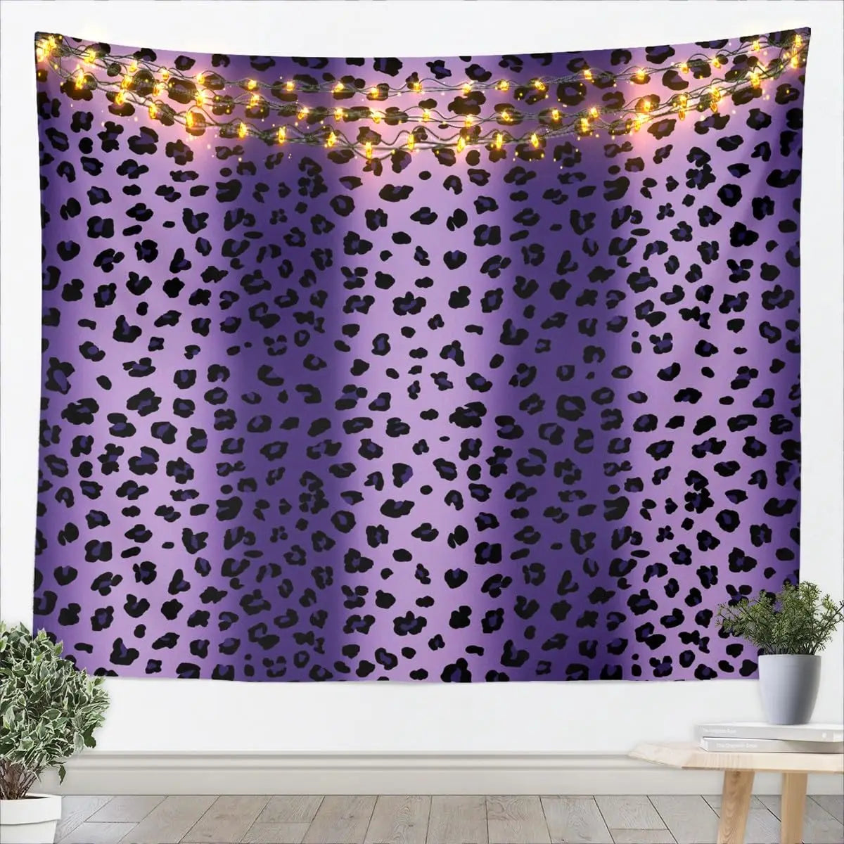 A purple leopard print tapestry wall hanging with warm string lights draped across it.