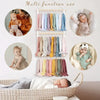 Wall-mounted headband holder for girls showing various colored hair accessories and baby products