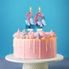 A pink birthday cake decorated with glitter candles shaped like the number 1 and 0, topped with pink frosting swirls.