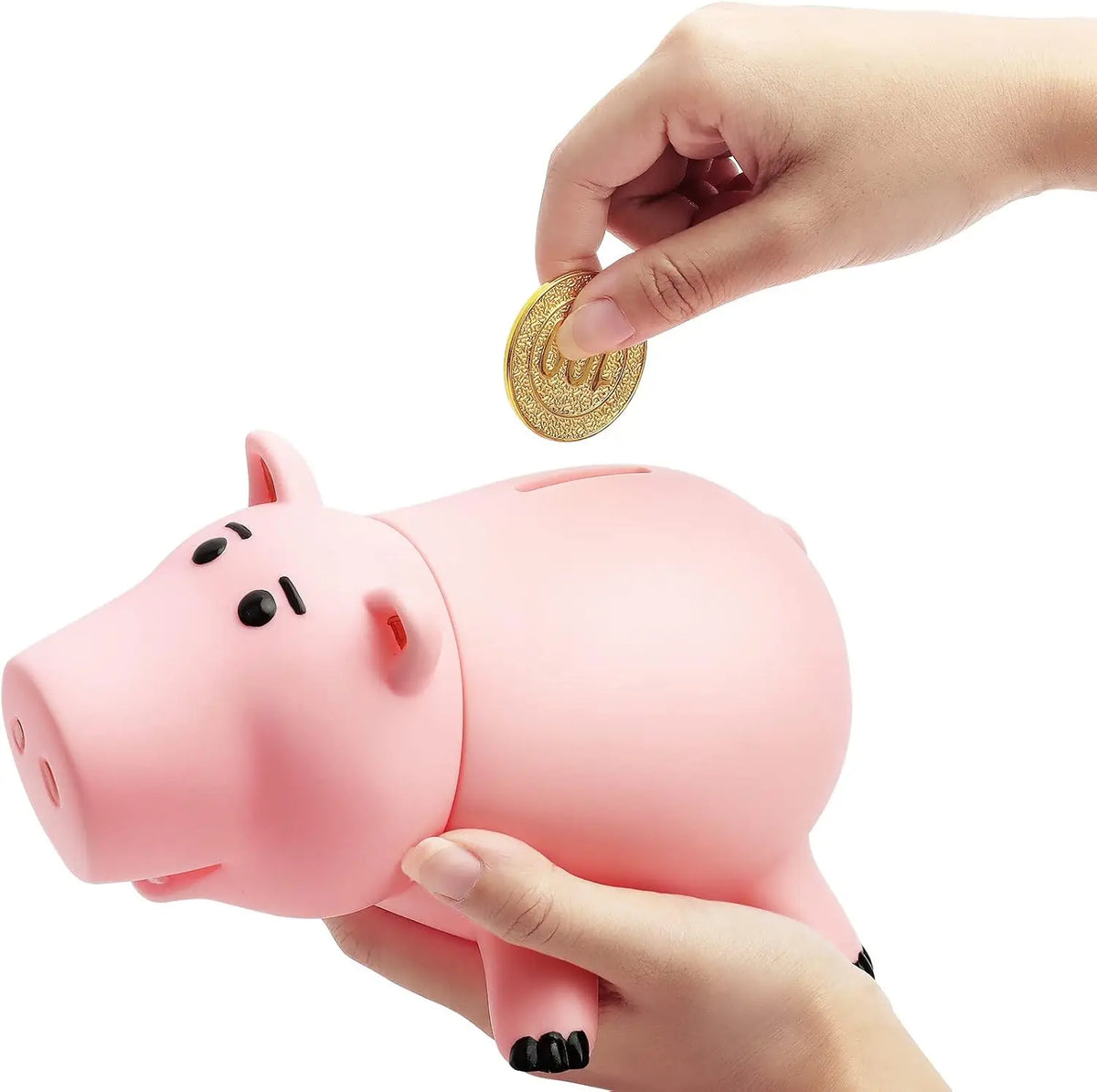A hand is depositing a gold coin into an adorable pink piggy bank for children.