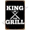 A black metal tin sign with white text that reads KING OF THE GRILL.
