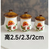 Three handcrafted miniature mushroom tableware items with golden lids displayed on a white surface.