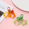 A set of colorful star charm pendants and keychains in orange, yellow, and green displayed on a pink background.