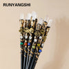 A bundle of natural clear quartz crystal wands with decorative gold accents for meditation and healing.