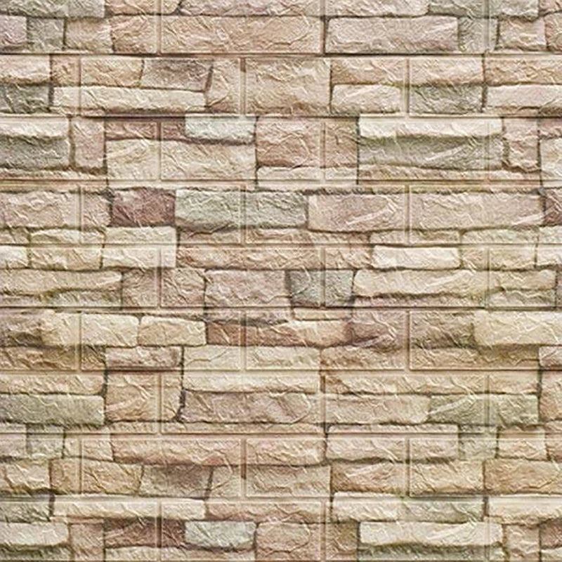 A textured stone veneer wall made of rectangular, stacked panels in beige and brown tones.