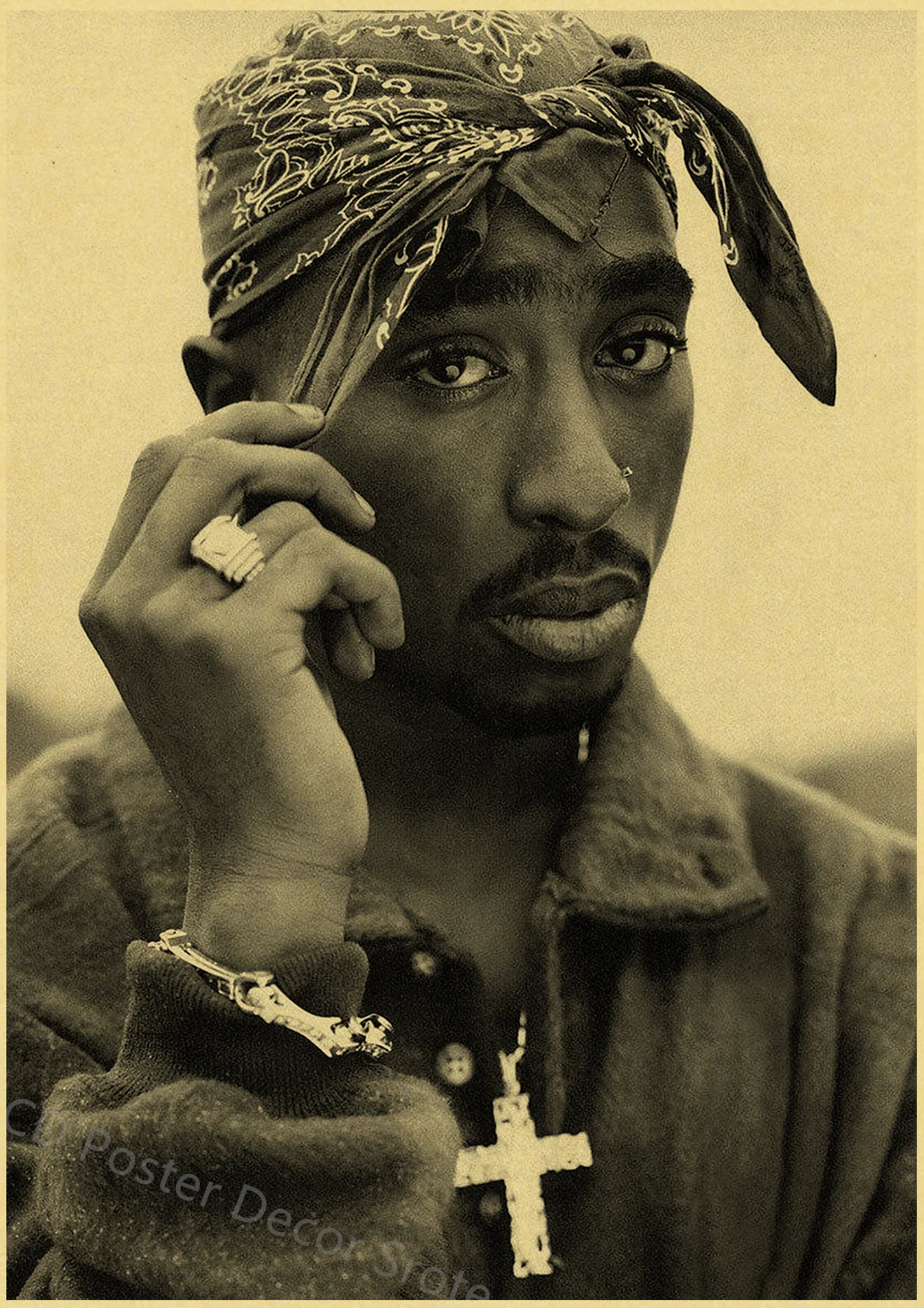 A close-up portrait of a man wearing a patterned headwrap and a jacket, holding his face with his hand.