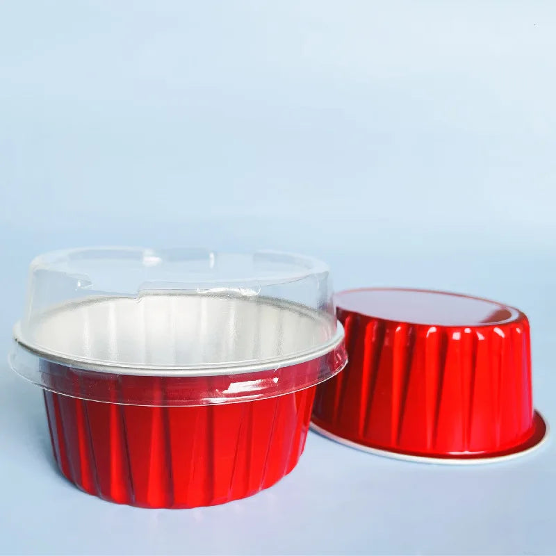 Red reusable aluminum foil dessert ramekins with lids displayed on a light blue background