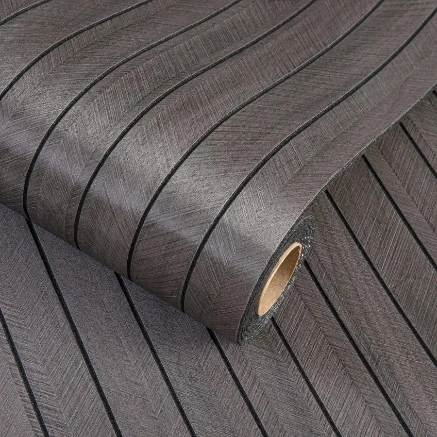 Roll of self-adhesive 3D wood grain wall panels in dark gray showing the textured surface and core.