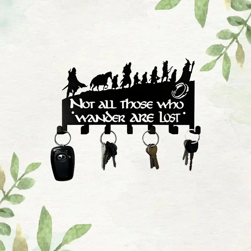 Black silhouette of figures on a sign with the text Not all those who wander are lost and seven metal hooks below