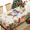 Festive red Christmas tablecloth featuring a snowman design and holiday decorations on a dining table.