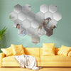 A heart-shaped wall decor featuring 12 self-adhesive hexagon mirrors depicting people.