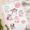 A sheet of white stickers featuring various cute pink and white cow cartoon designs.
