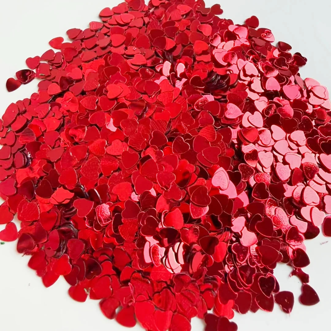 A pile of red heart-shaped foil confetti for parties and celebrations.