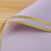 Light purple wrapping paper with a gold edge design shown in a close-up view.