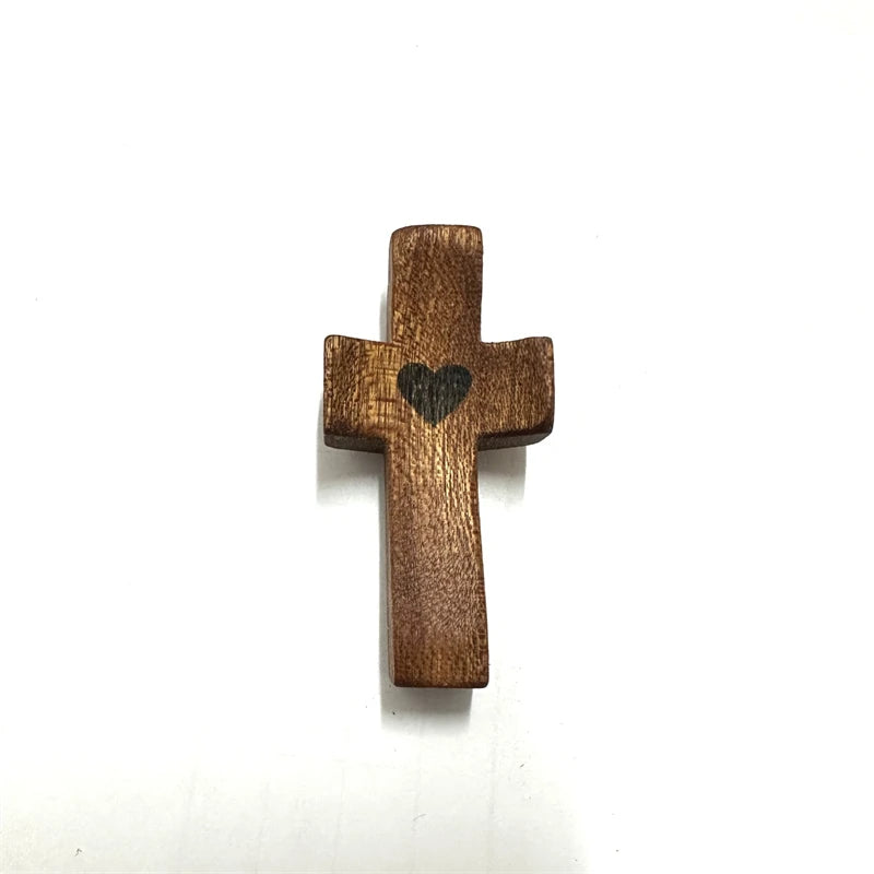 A small wooden cross with an epoxy heart detail, used for spiritual comfort.