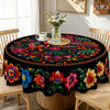 A vibrant Mexican style embroidered tablecloth featuring colorful floral patterns on a round table.