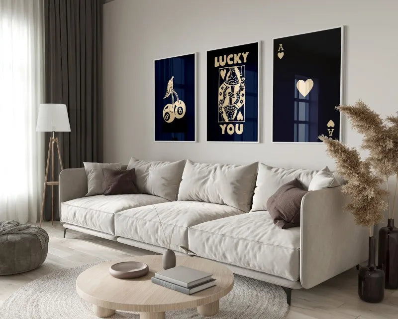 A modern living room features a light sofa and wooden coffee table with a set of dark framed art prints.
