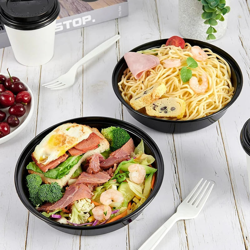 A bowl of stir-fried noodles topped with ham, shrimp, and vegetables served on a white wooden surface.