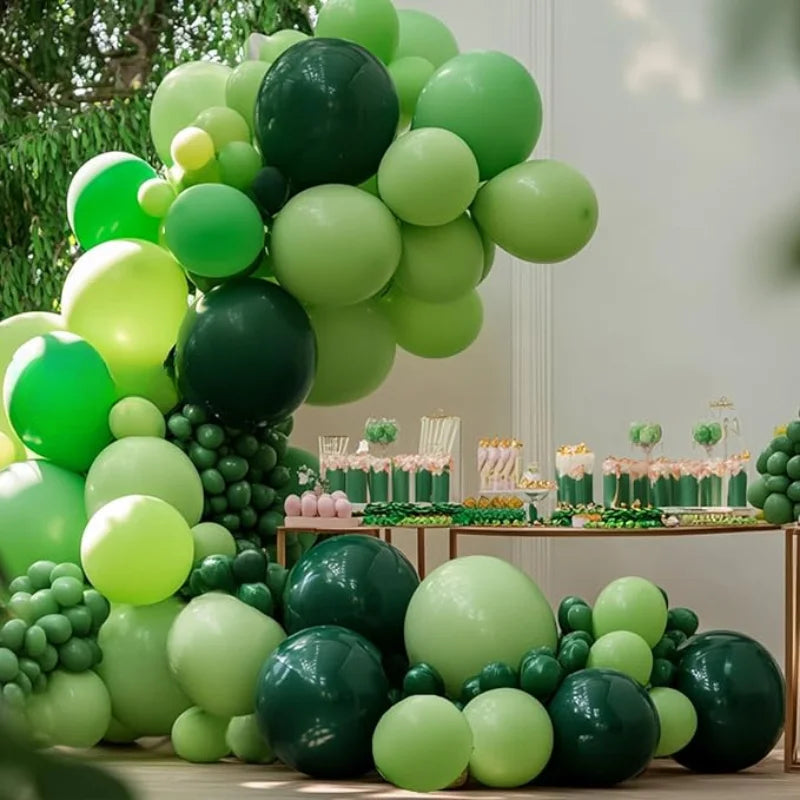 A lush green balloon garland arch kit featuring various shades of lime and dark green balloons for parties and events.