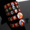 A wooden rosary bracelet featuring multiple charms of the Virgin Mary and Jesus.
