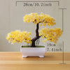 Artificial tree bonsai decoration with bright yellow foliage planted in a white rectangular pot