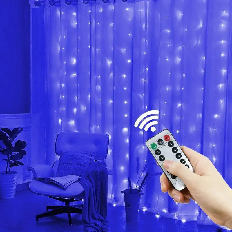A hand holds a remote controlling blue LED curtain lights illuminating a sheer purple fabric backdrop.