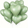 A bunch of ten light green heart-shaped foil balloons tied together for a celebration.