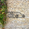 Metal wall art depicting a sleek modern sports car silhouette on a light-colored stone wall.