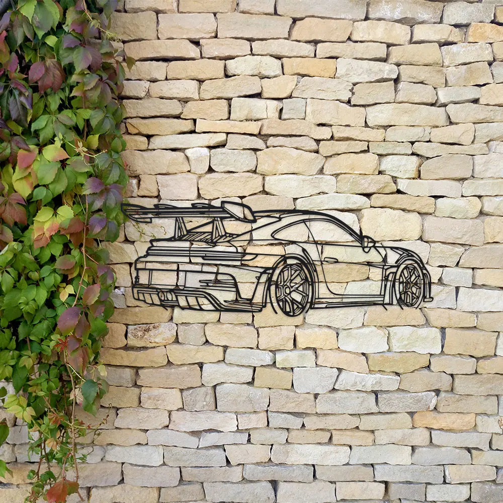 Metal wall art depicting a sleek modern sports car silhouette on a light-colored stone wall.