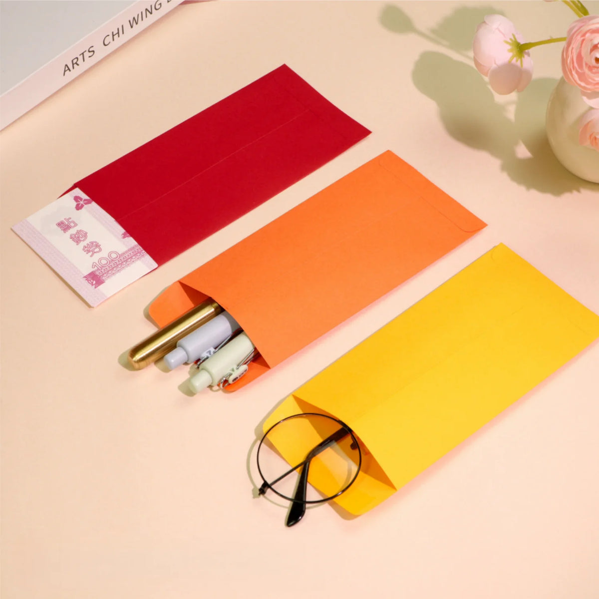 A set of colorful side-loading cash envelopes in red, orange, and yellow are displayed on a light background.