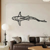 Black metal line sculpture of a shark swimming across a white wall above a dark brown sofa.