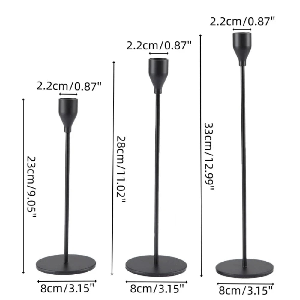 Set of three black metal taper candle holders with varying heights and bases